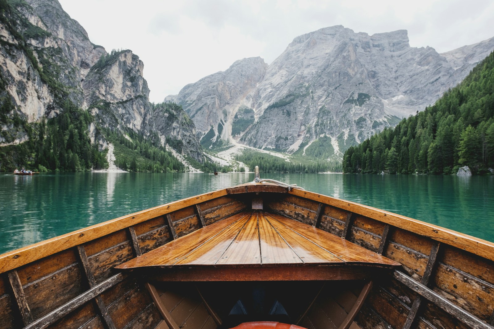 Canoe on a calm lake between green mountains
